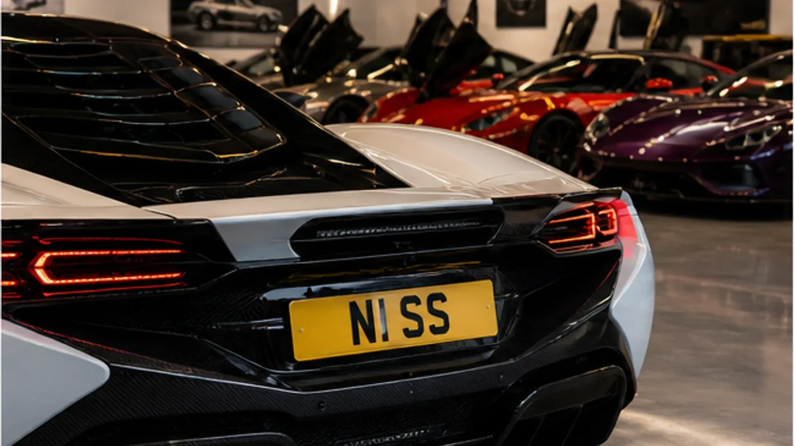 Supercar collection in a premium garage with a personalised plate